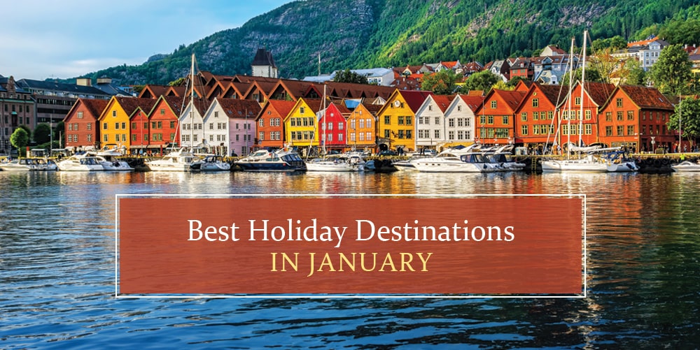 The image depicts a picturesque harbor town with colorful, traditional buildings lining the waterfront. Boats are moored in the calm waters, reflecting the vibrant hues of the structures. The text overlay announces "Best Holiday Destinations IN JANUARY", suggesting this location as an ideal travel destination during that time of year.