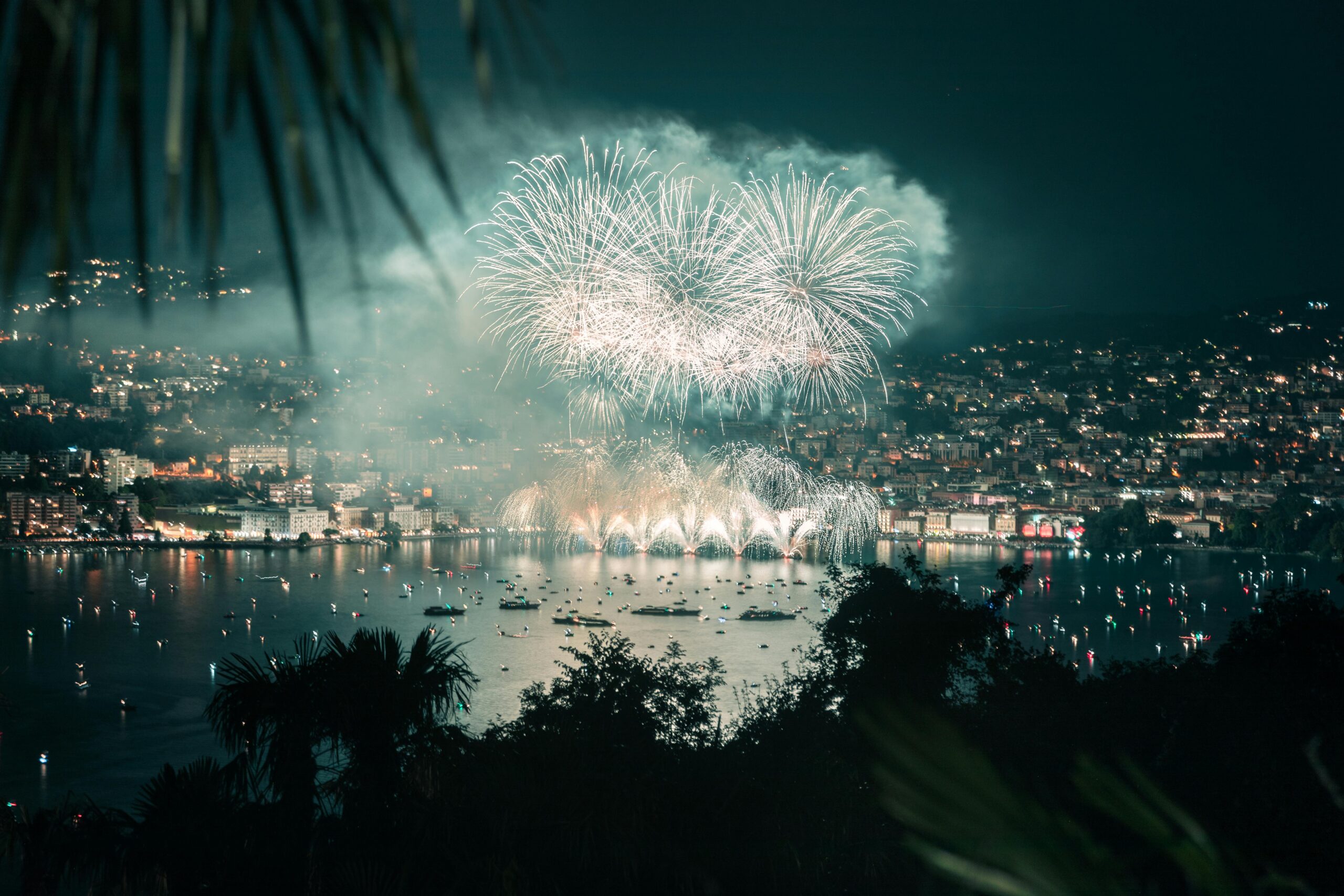 Stunning fireworks display over the city of Orlando, Florida, illuminating the night sky and reflecting on the calm waters below.